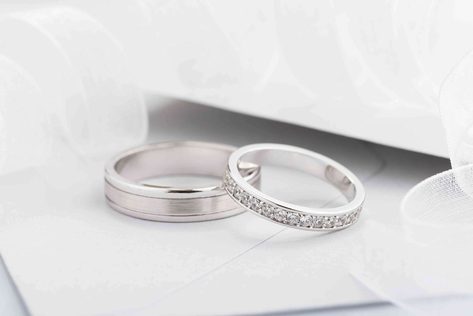 Silver diamond band ring on a white table