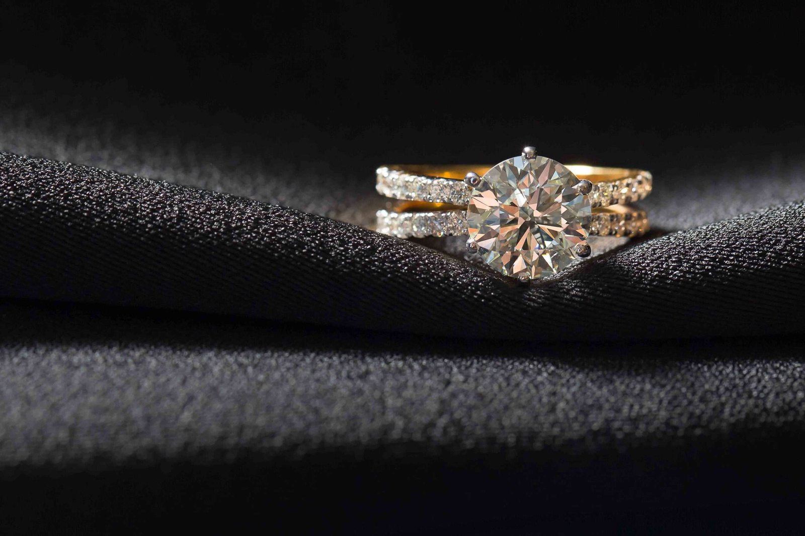 Gold diamond ring on a black fabric
