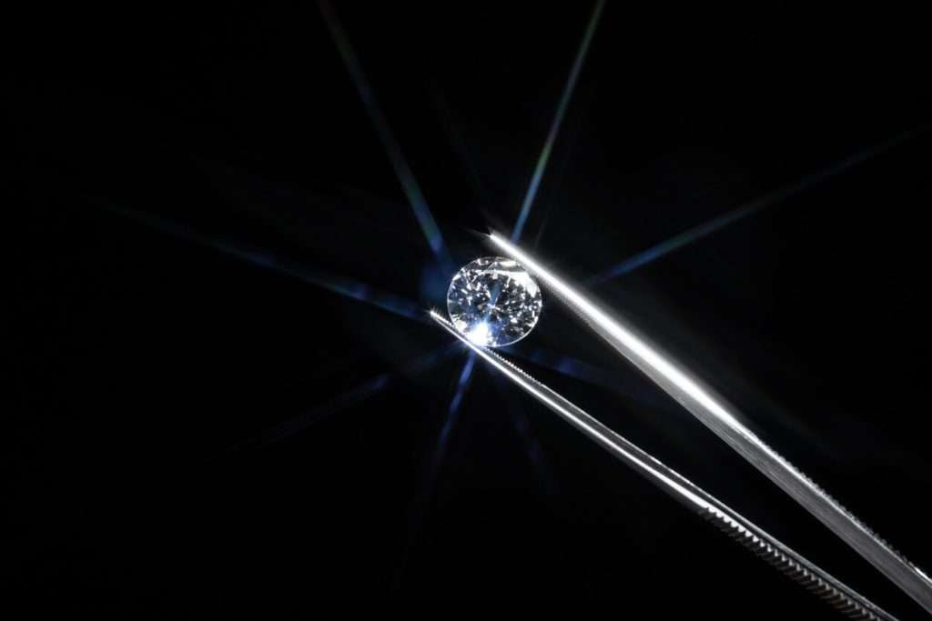 Sparkling diamond held on tweezers