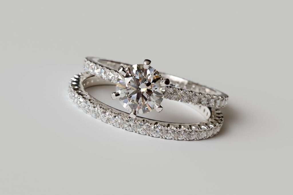 Diamond engagement ring, wedding ring on light gray background