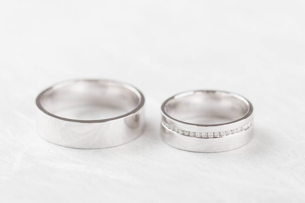 Two white gold wedding band ring on a white table
