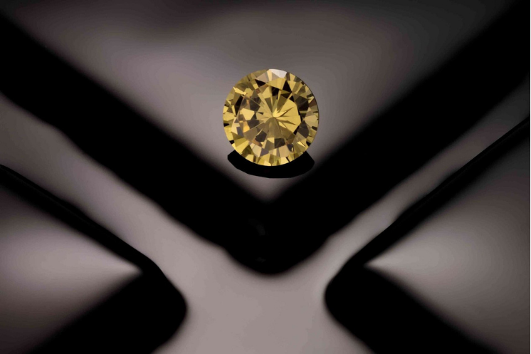 Round yellow gemstone on a black background